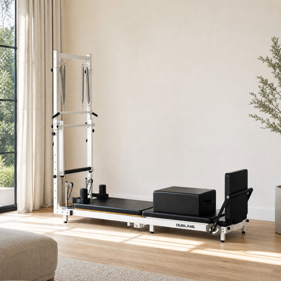 OUBLANC's RT-101 Foldable Pilates Reformer with Tower, shown in a bright, modern room with beige walls, light wood floors, and a window on the left.