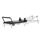 OUBLANC RT-101 Foldable Pilates reformer machine with a black padded carriage, white steel frame, and black foot bar, shown on a solid white background.