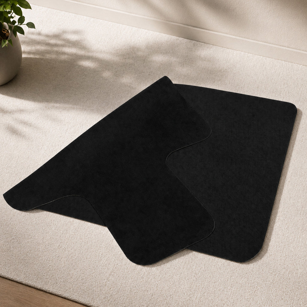 A black Pilates reformer folded on a beige carpet.