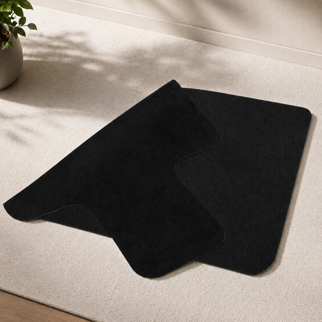 A black Pilates reformer folded on a beige carpet.